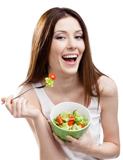 Dieting woman eats green salad in salad bowl, isolated on white