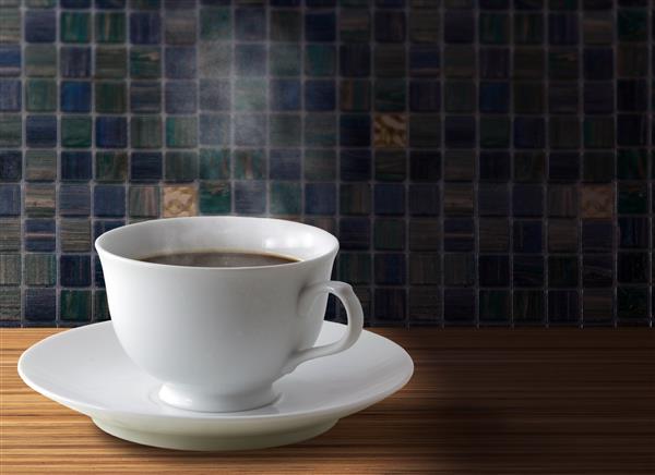 Coffee cup with burlap sack of roasted beans on rustic table